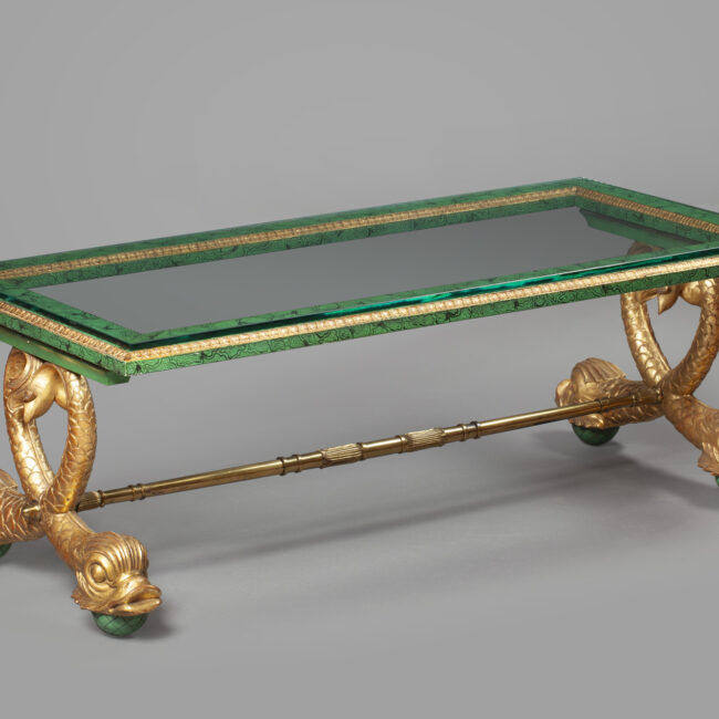 A gilt-bronze mounted glass coffee table with dolphin legs